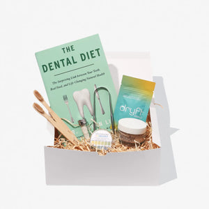 Wonder basket containing The Dental Diet book, bamboo toothbrush, silk floss, Dryft mouth tape, peppermint tooth powder, oral PH strips and a tongue cleaner