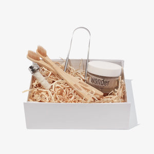 Basket containing Wonder natural silk floss, bamboo toothbrush and peppermint tooth powder