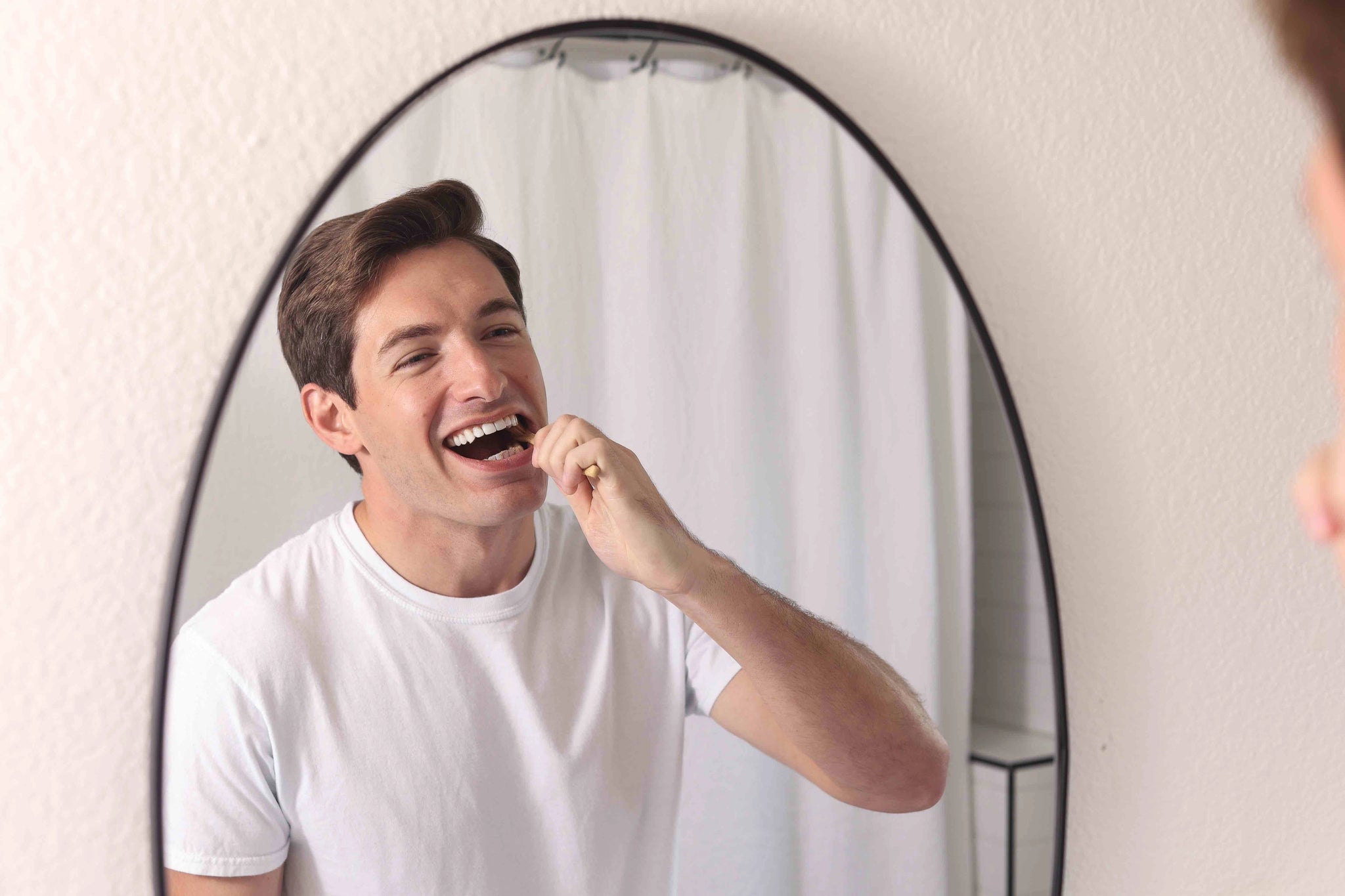 Man brushing teeth with Wonder bamboo toothbrush
