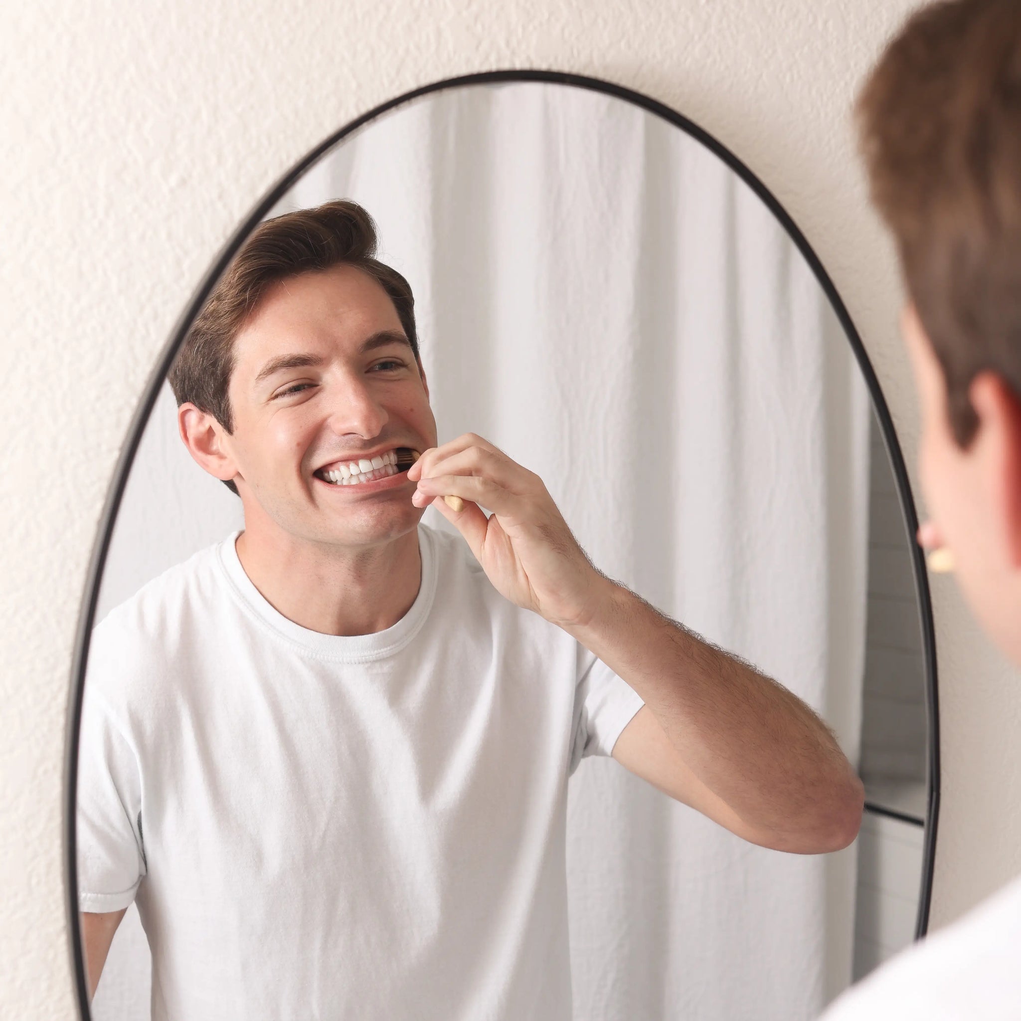 man brushing teeth with Wonder bamboo toothbrush
