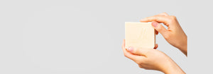 Grey background with person holding Living Home toxic-free soap